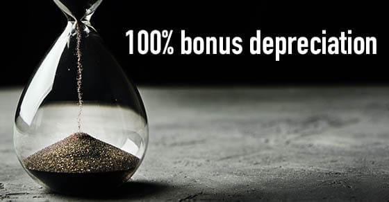 Hourglass on a dark background, long banner. Urgency and running out of time concept Hourglass on dark background, long banner. Urgency and running out of time concept with text "100% bonus depreciation"